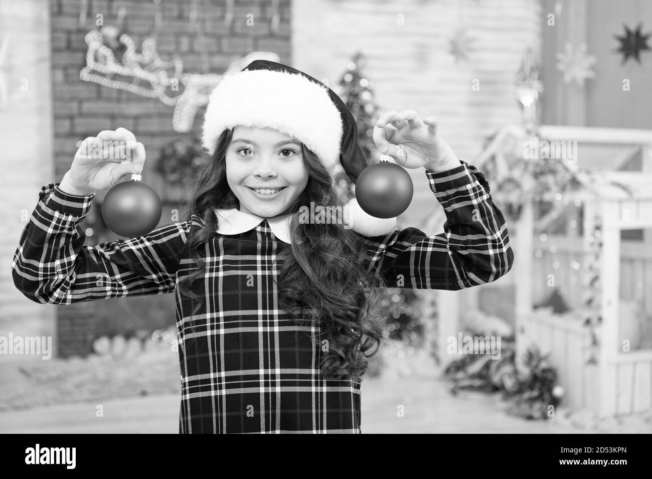 Ambiance de fête. La décoration de son activité favorite. Boutique de décoration. Accueil décorations de sélection. Enfant decorating Christmas Tree balls. Kid Girl decorating Christmas Tree. Kid santa hat near christmas tree. Banque D'Images