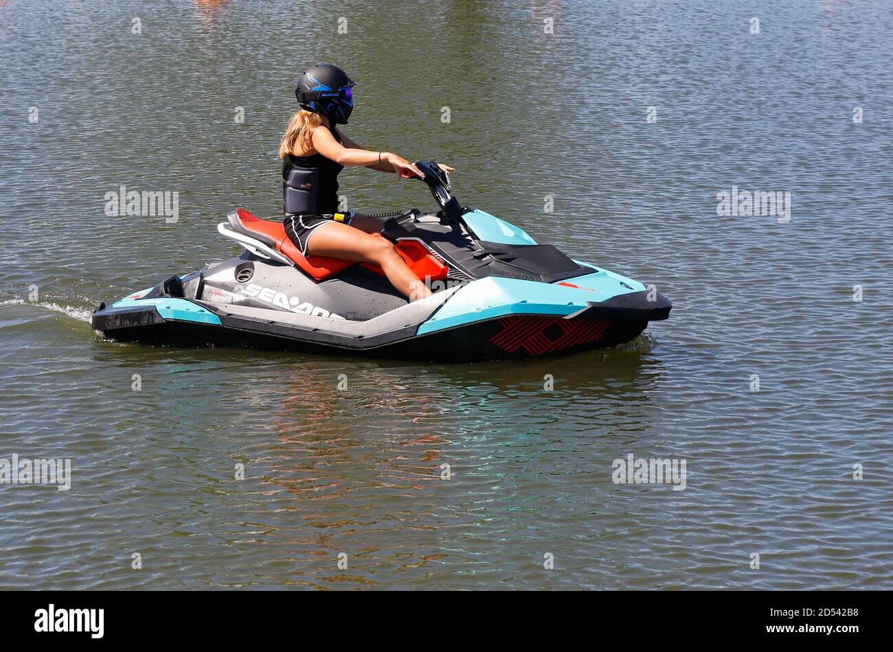 Mariestad, Suède - 23 juin 2020 : une femme pilote de jet ski tournant lentement dans le port. Banque D'Images