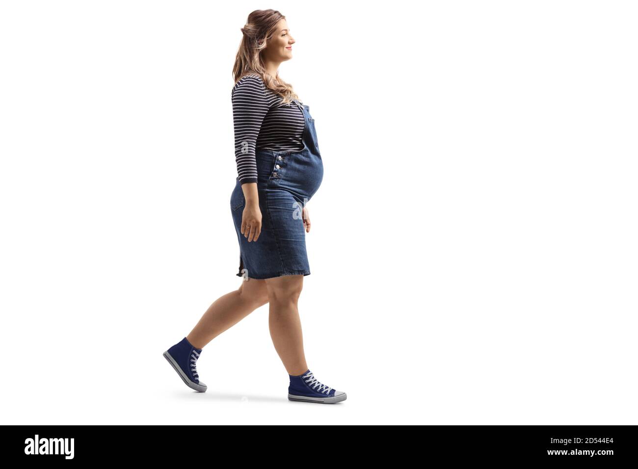 Prise de vue en longueur d'une femme enceinte marchant isolée arrière-plan blanc Banque D'Images