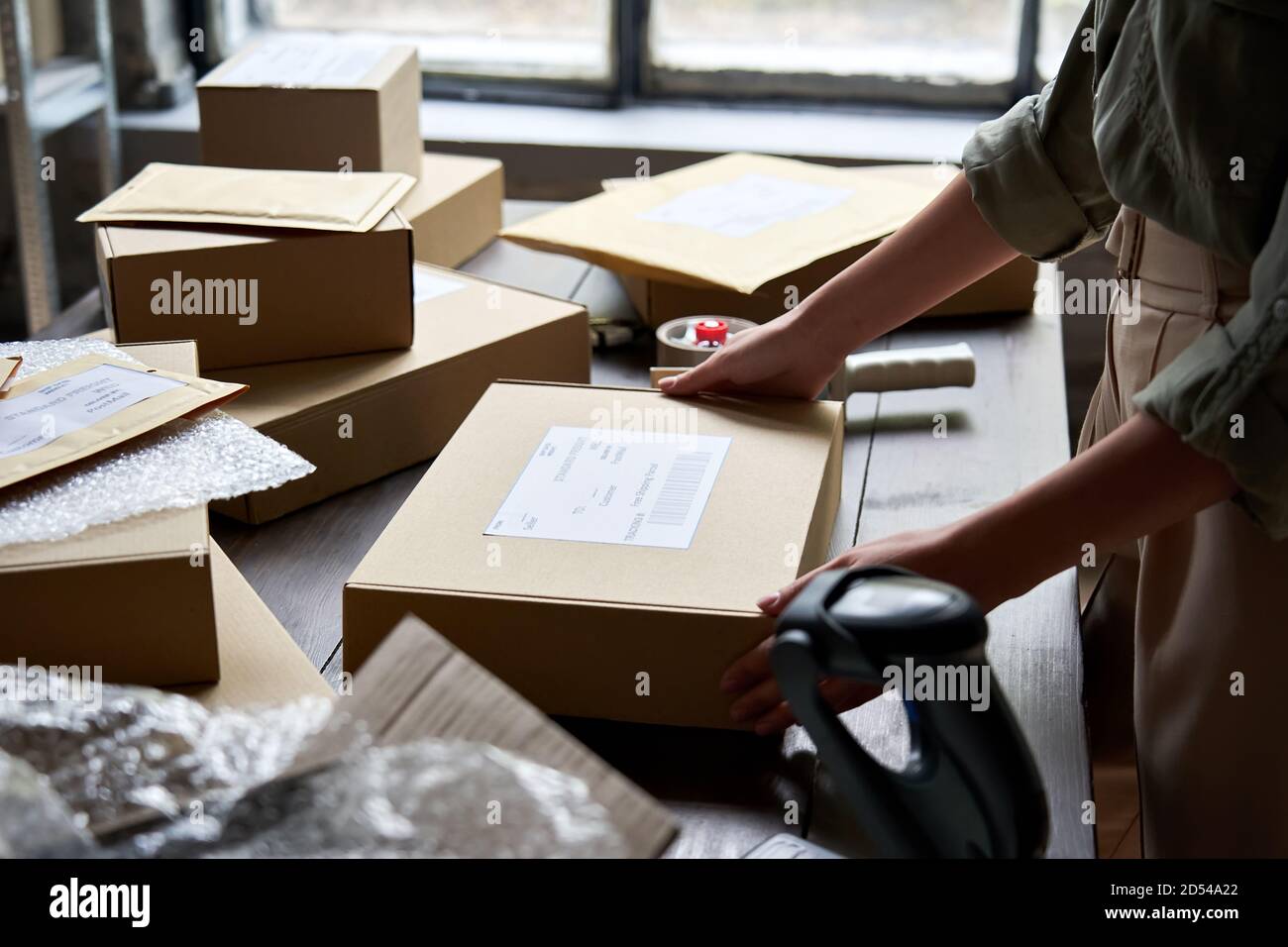 Femme vendeur d'entrepôt emballant la boîte de commande d'expédition pour l'expédition. Banque D'Images