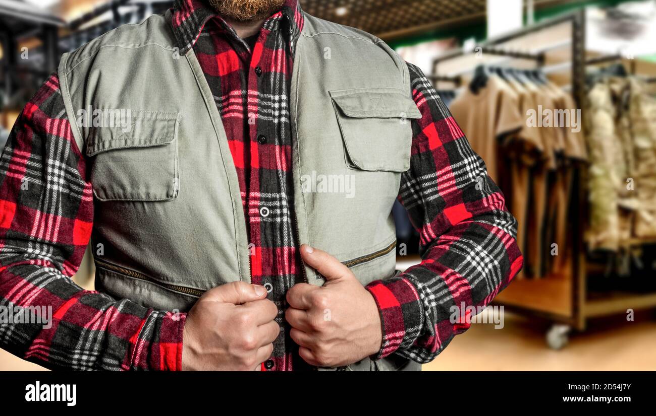 Photo d'un homme barbu dans un magasin uniforme portant une veste de chasse. Banque D'Images