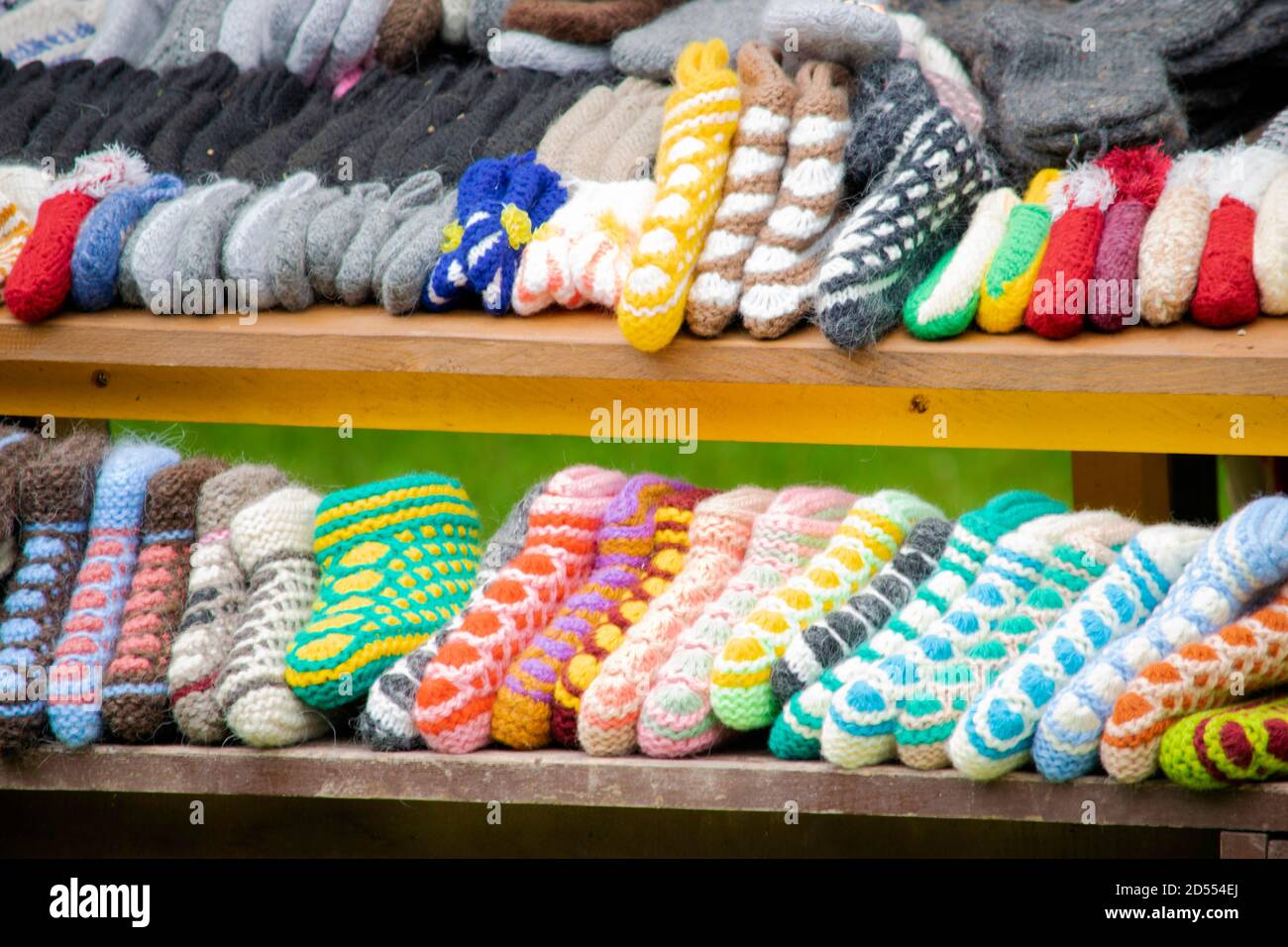 des chaussettes et des chaussons tricotés multicolores faits main sont disposés sur la fenêtre d'un marché de rue Banque D'Images