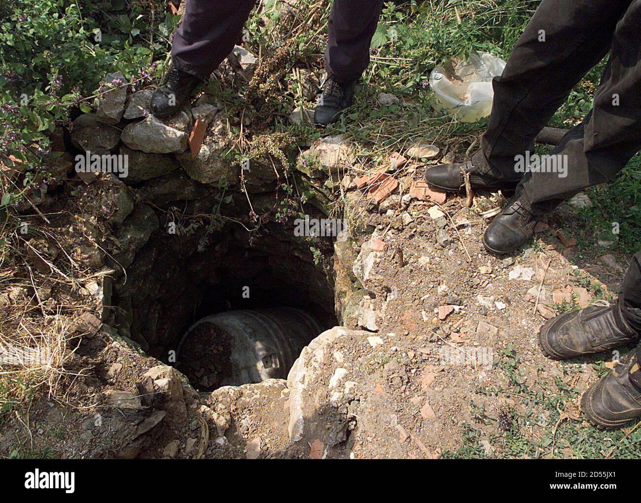 Les Albanais du Kosovo font le tour d'un puits, recouvert d'une boîte en  plastique dans un village de la région de Drenica, à l'ouest de Pristina,  le 16 juin. Les reporters de