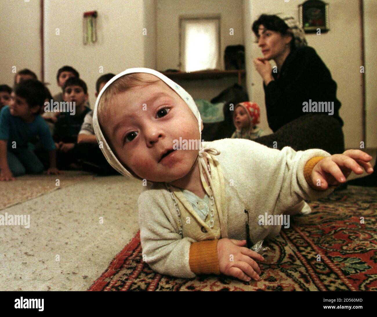 Un bébé tchétchène traverse le plancher d'une maison de prière de voyageurs  qui est maintenant le foyer de 53 réfugiés, dans le village de Nasyr Kort  en Ingouchie novembre 20. Vendredi, le