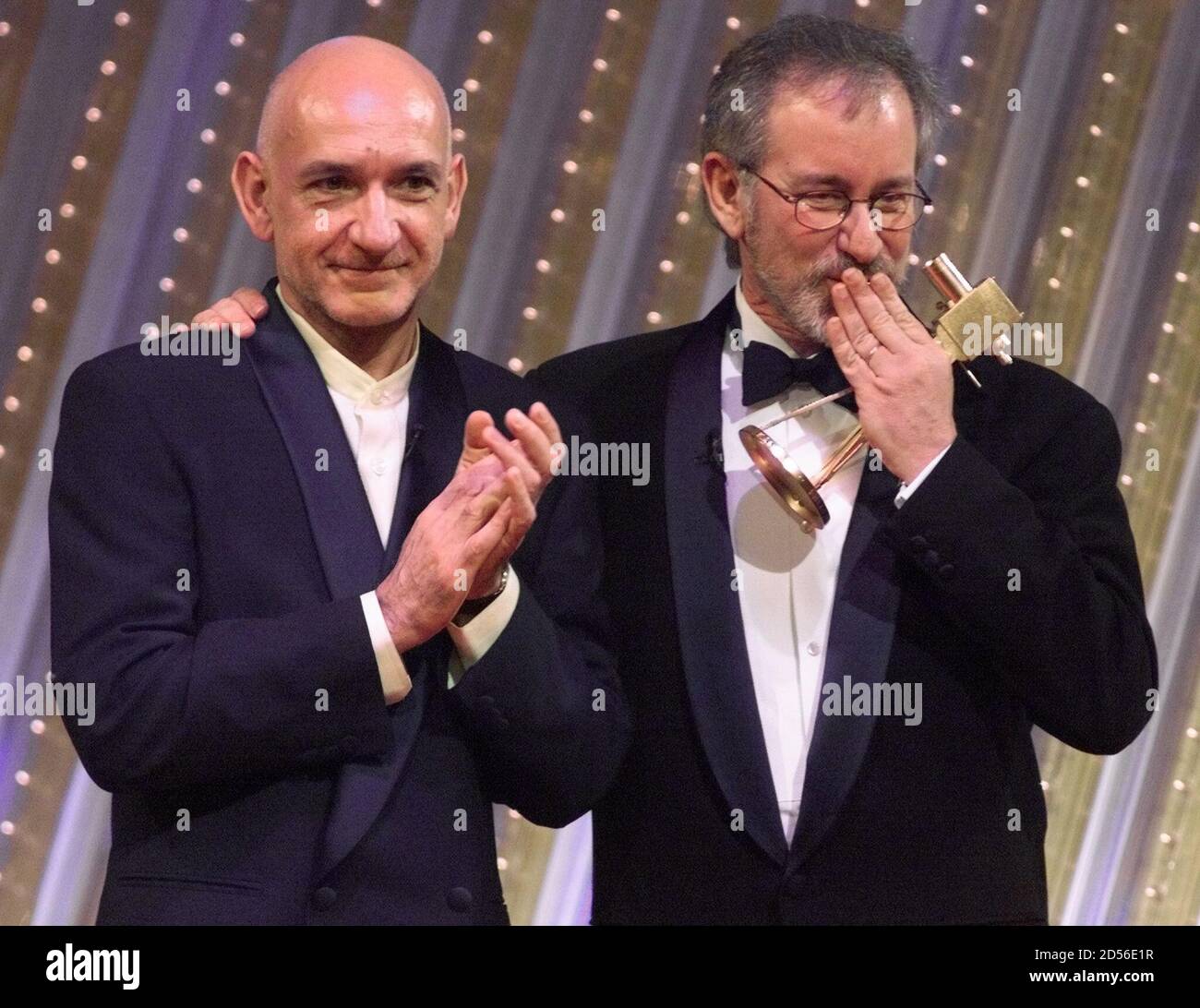 U.S. film director Steven Spielberg (R) gives a kiss to the audience as he  embraces British actor Ben Kiknsley (L) after he receives the ''Golden  Camera'' award for the millennium as "
