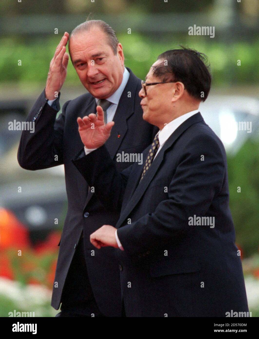 France's President Jacques Chirac (L) steadies his hair as China's  President and Communist Party boss Jiang Zemin (R) makes a point during  windy welcome ceremonies at Beijing's Great Hall of the People