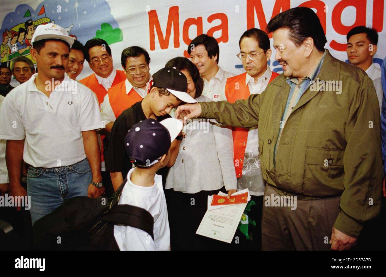 Gerald Ortega (C), 11, kisses the hand of Philippine President Joseph  Estrada as a sign of respect after he and his family arrived at the Manila  international airport December 28. Estrada gave