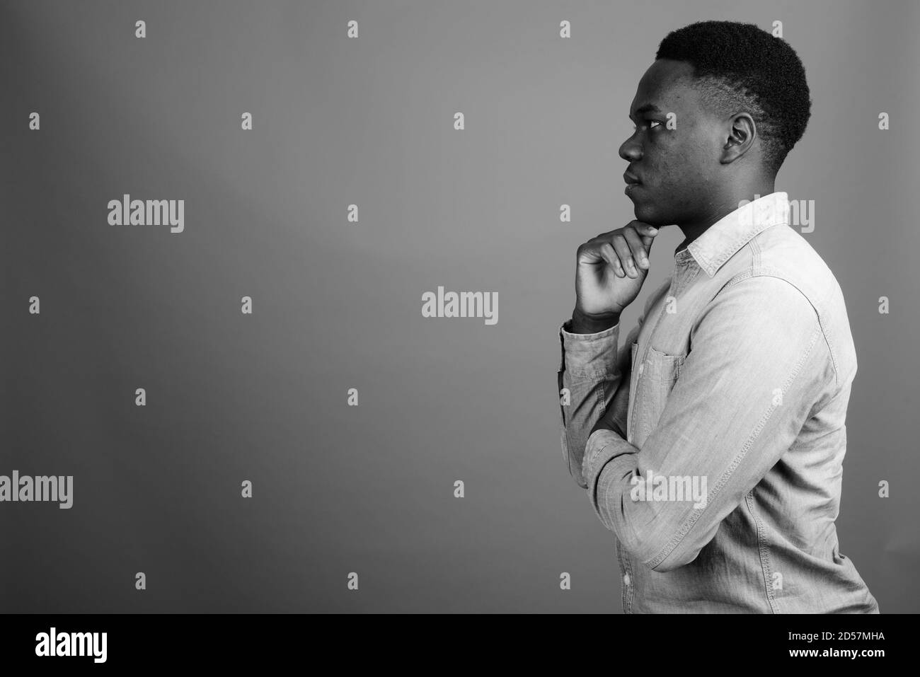 Young African man wearing denim shirt contre l'arrière-plan gris Banque D'Images