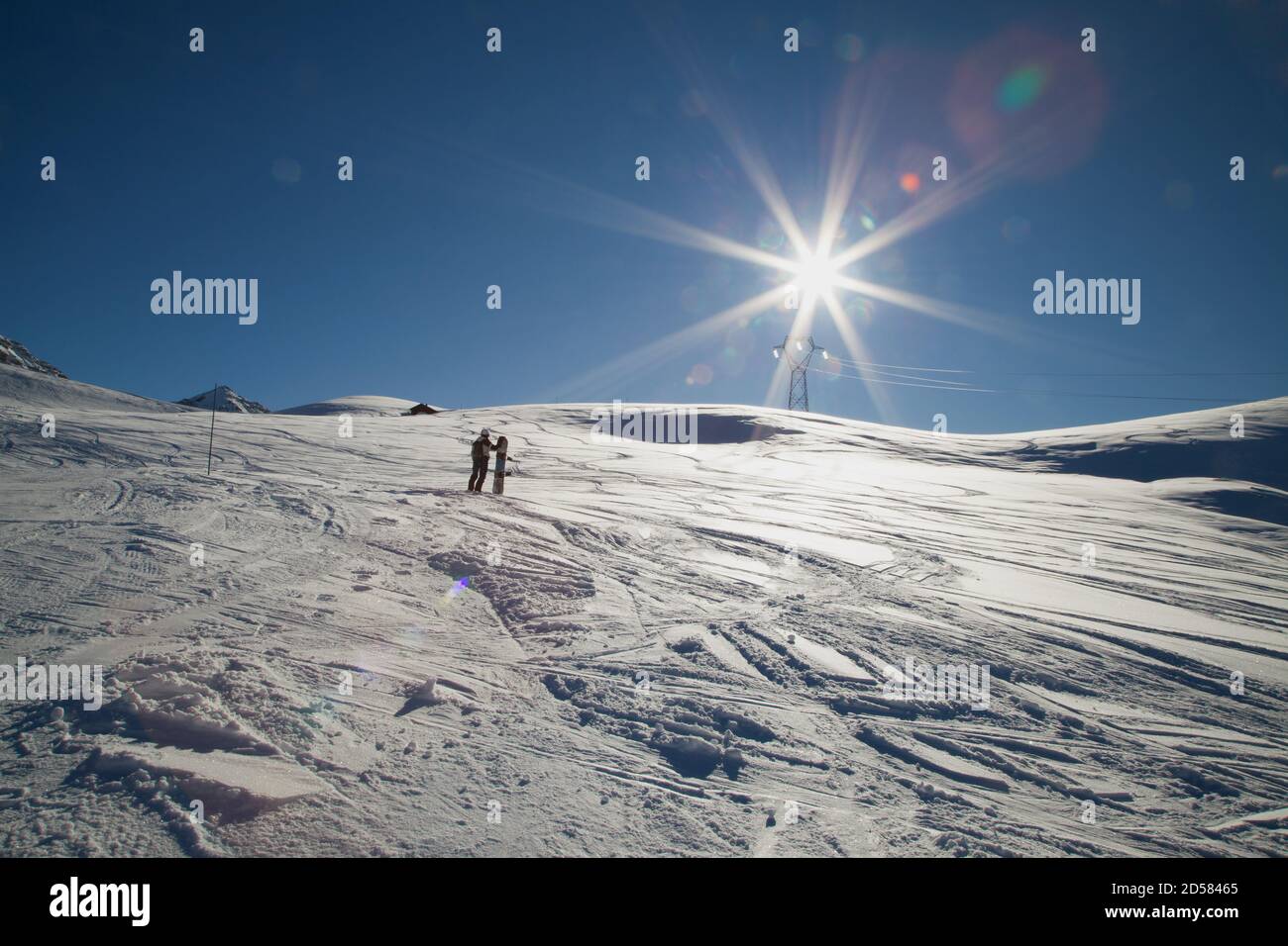 Saint-François-Longchamp : journée ensoleillée d'altitude sur une piste de ski avec un homme qui prend le temps d'avoir un regard sur le soleil. Tarentaise Savoie Banque D'Images