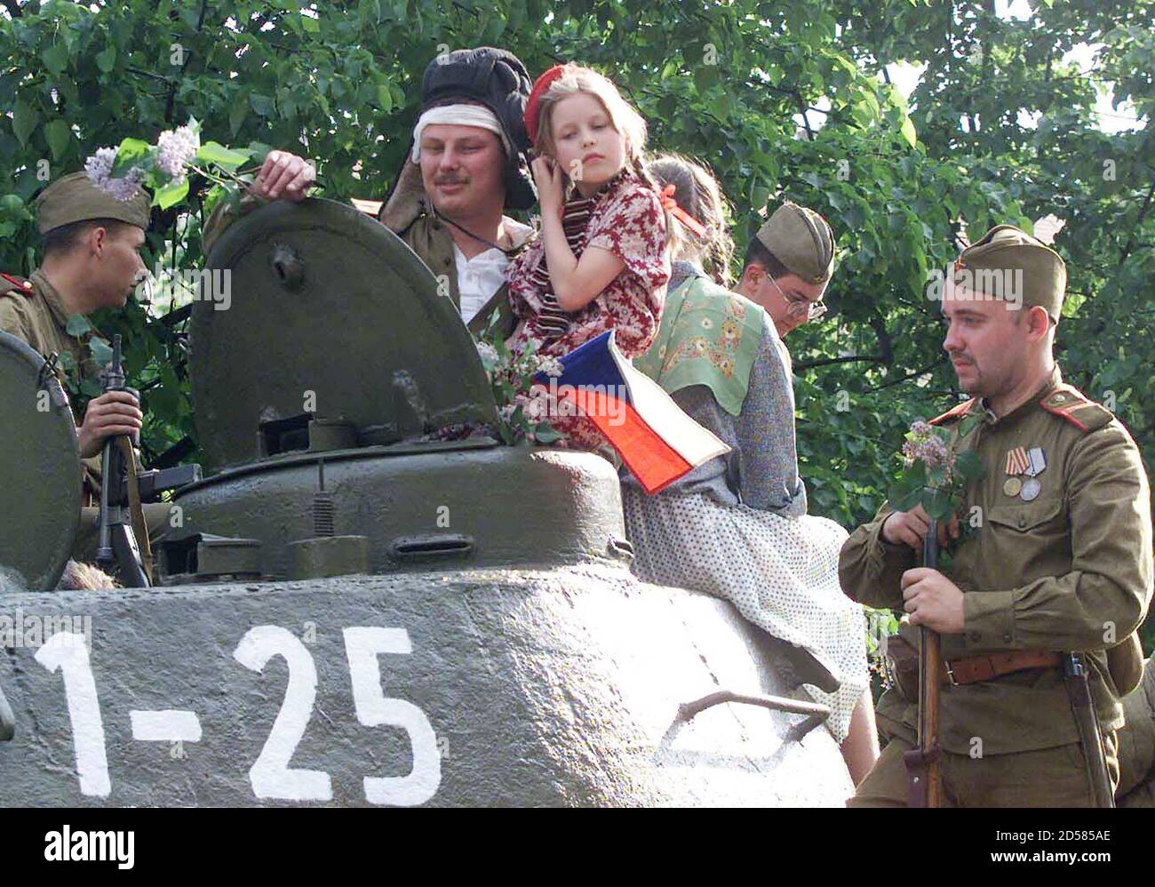 Une petite fille est tenue par un homme en uniforme de l'armée soviétique  au-dessus d'un char soviétique T-34 lors d'une représentation "bataille  pour la Barricade" à Prague, le 7 mai. Il y