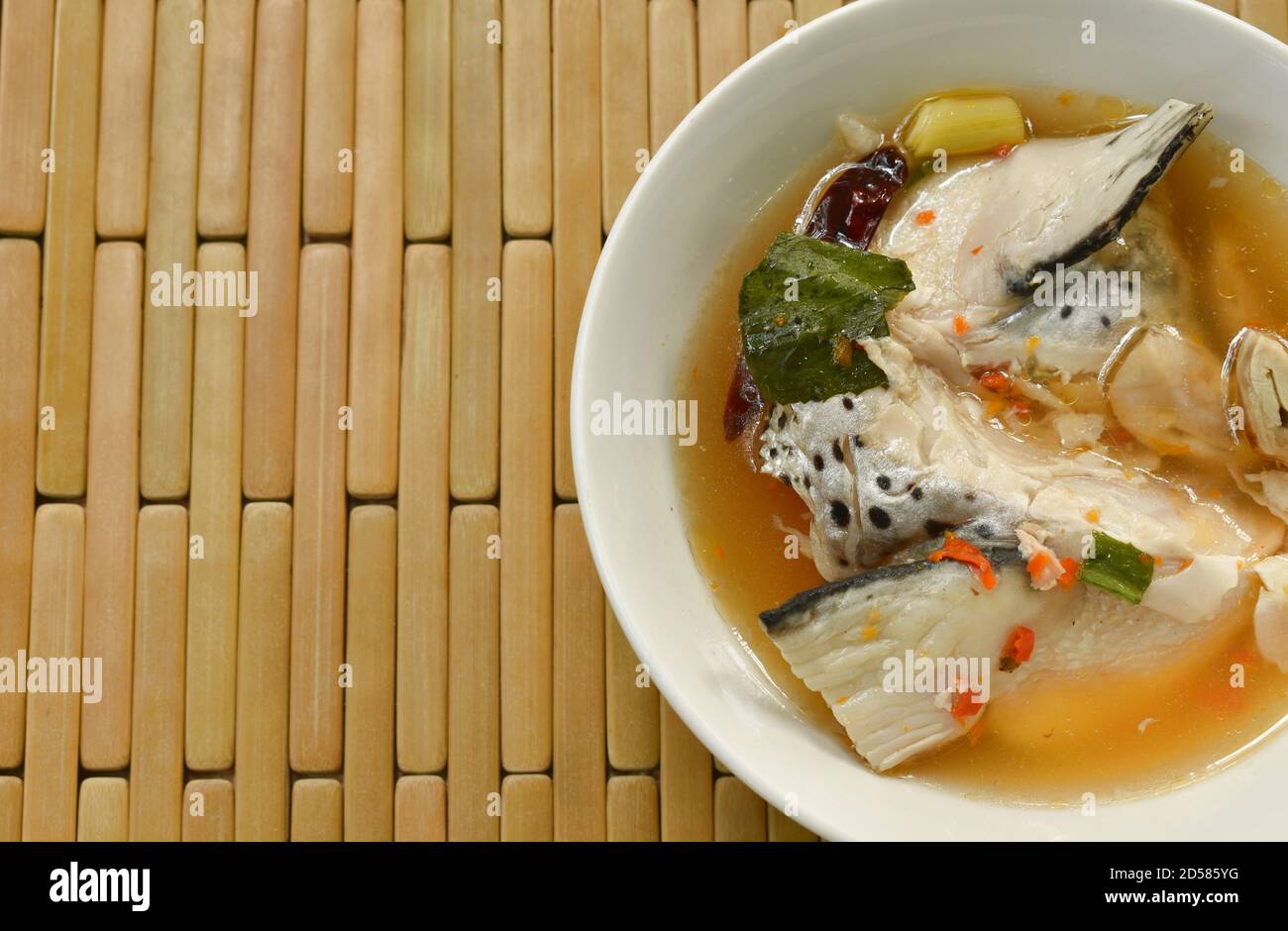 Tête de poisson de saumon épicée et champignon de la paille à Tom Yum soupe sur bol Banque D'Images