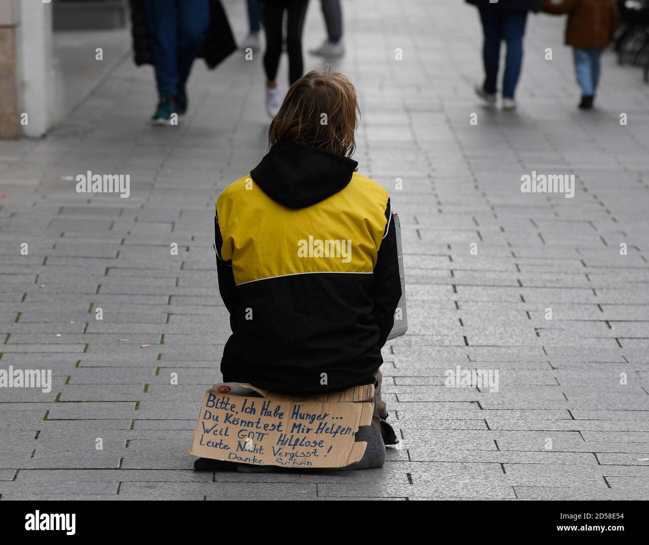 Düsseldorf, Allemagne. 13 octobre 2020. Une personne est assise au milieu du pavé de la Königsallee et demande des almes. L'affiche en carton indique : « s'il vous plaît, J'ai faim. Vous pourriez m'aider, parce que Dieu n'oublie pas les gens impuissants! Merci. Credit: Roberto Pfeil/dpa/Alay Live News Banque D'Images