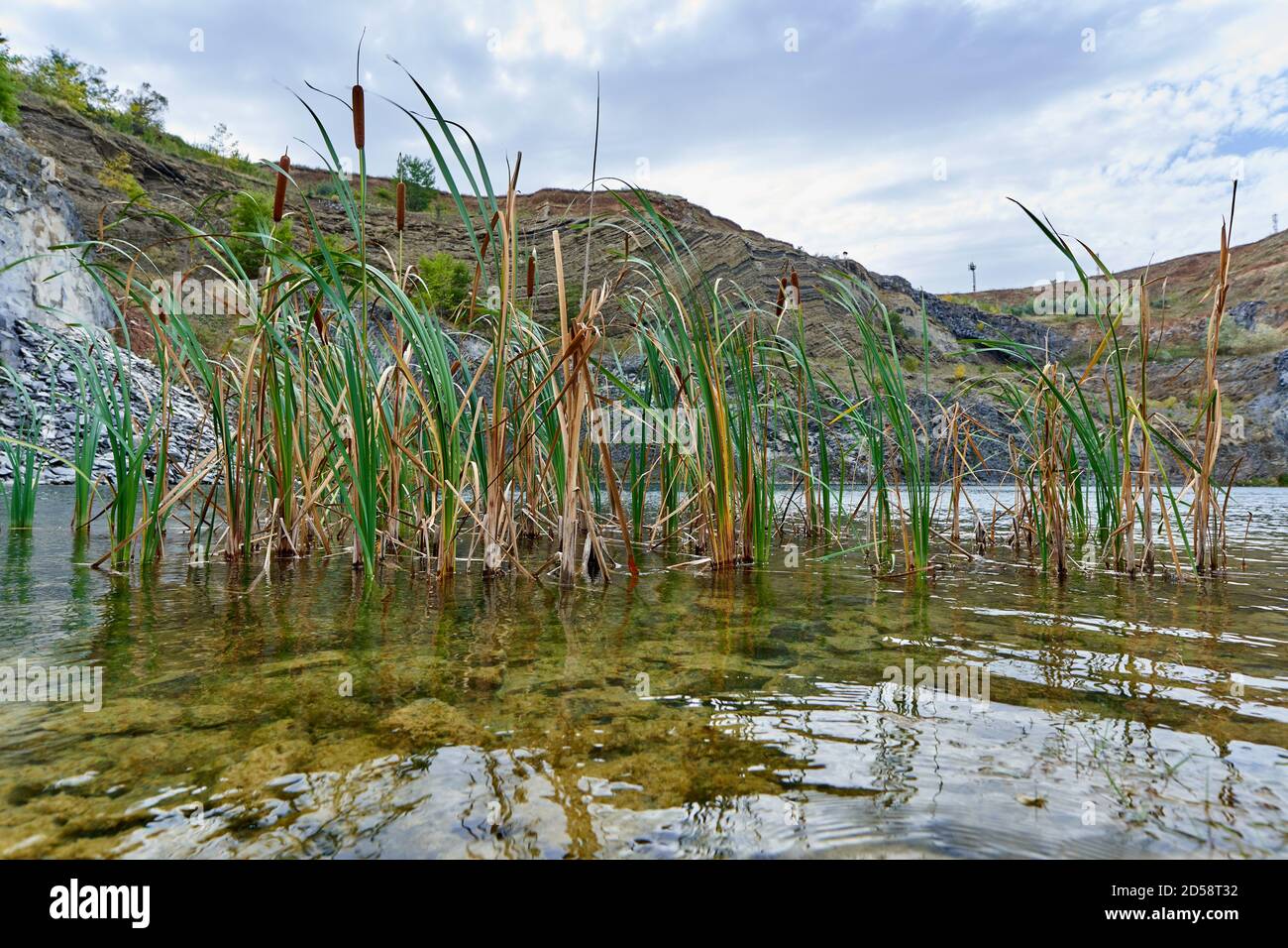 Paysage avec un lac formé dans une ancienne carrière avec roches sédimentaires et couches géologiques visibles Banque D'Images