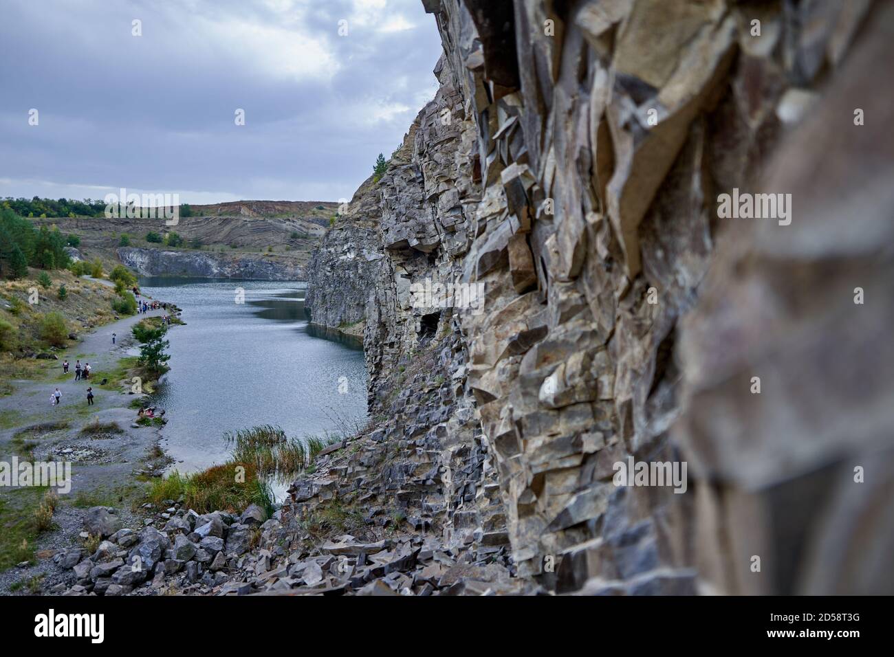 Paysage avec un lac formé dans une ancienne carrière avec roches sédimentaires et couches géologiques visibles Banque D'Images