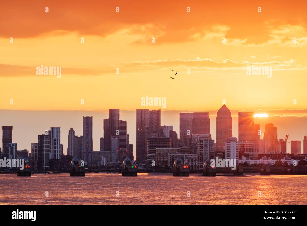 La Tamise, la barrière de la Tamise et les gratte-ciel de Canary Wharf au coucher du soleil, Londres, Angleterre, Royaume-Uni Banque D'Images