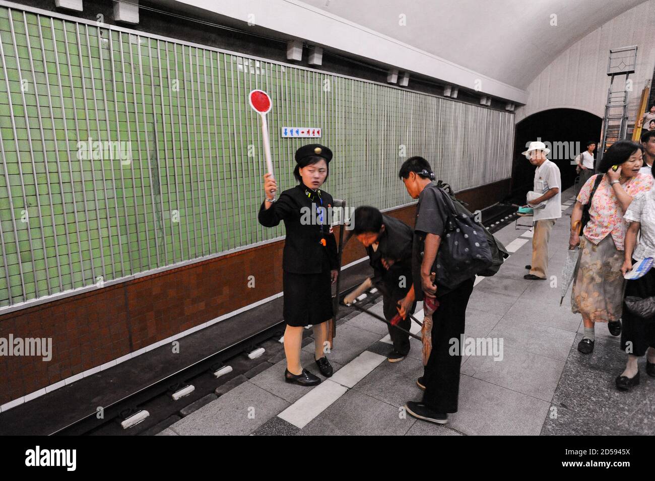 09.08.2012, Pyongyang, Corée du Nord, Asie - UNE femme de la plate-forme signale à une station de métro de Pyongyang dans la capitale. Banque D'Images