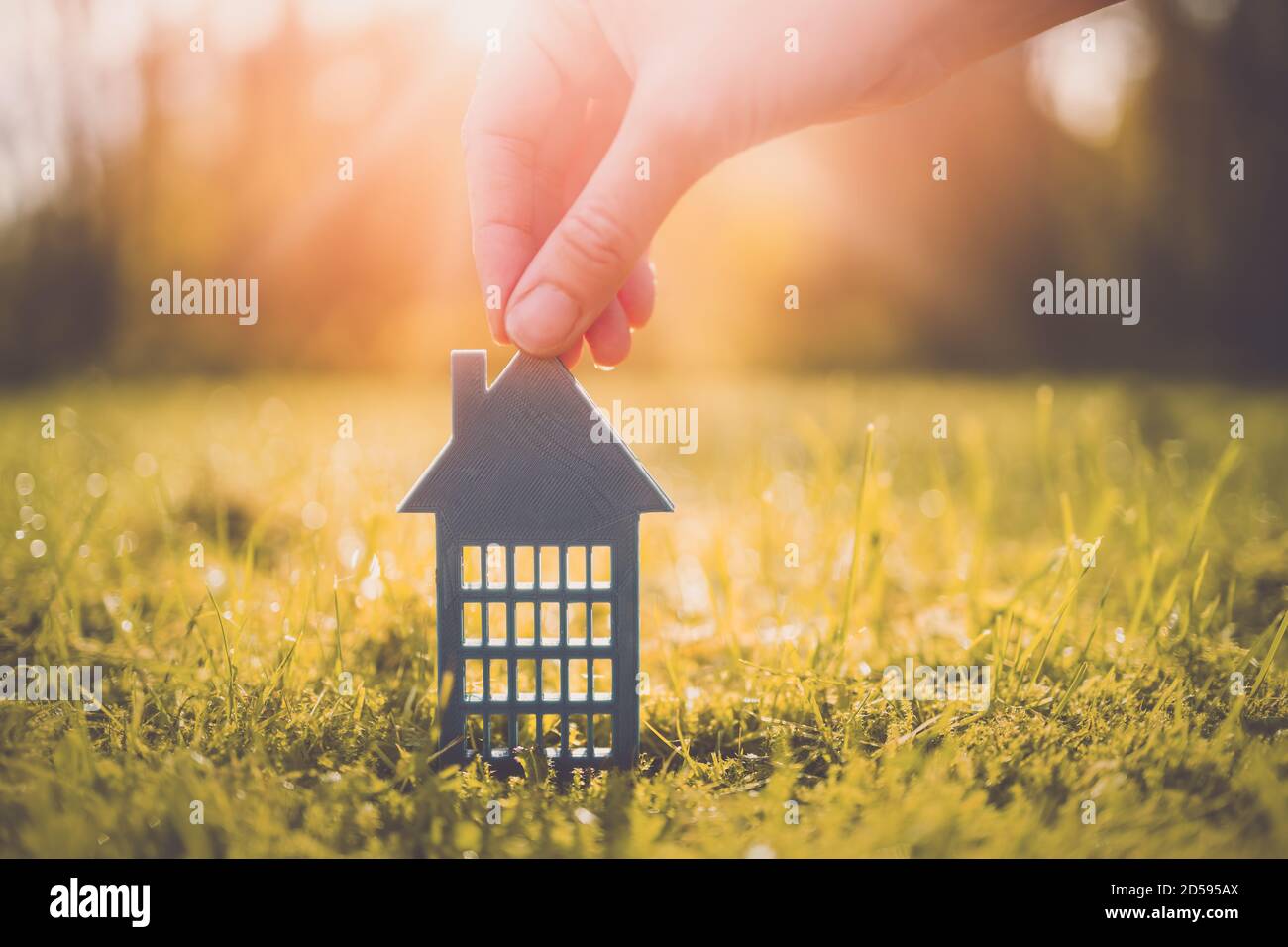 Modèle de maison d'appartement grise sur l'herbe jaune d'automne par une journée ensoleillée. Banque D'Images