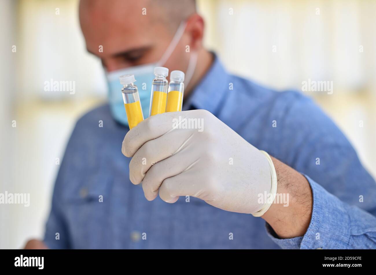 Portrait d'un médecin tenant trois échantillons de laboratoire Banque D'Images