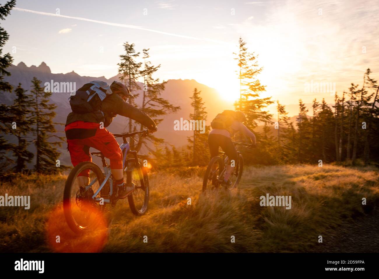 Vue arrière de deux adultes VTT en montagne au lever du soleil, Fadstadt, Salzbourg, Autriche Banque D'Images