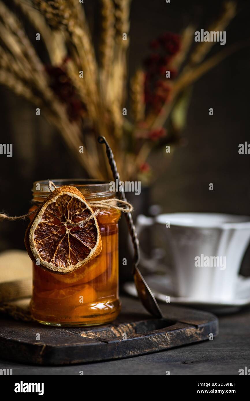 Tasse de thé, confiture d'orange et fleurs séchées sur une table en bois Banque D'Images