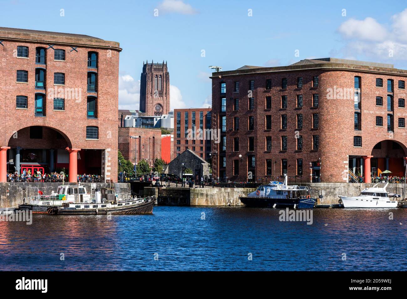 La tour de la cathédrale anglicane de Liverpool entre deux bâtiments à quai. Banque D'Images