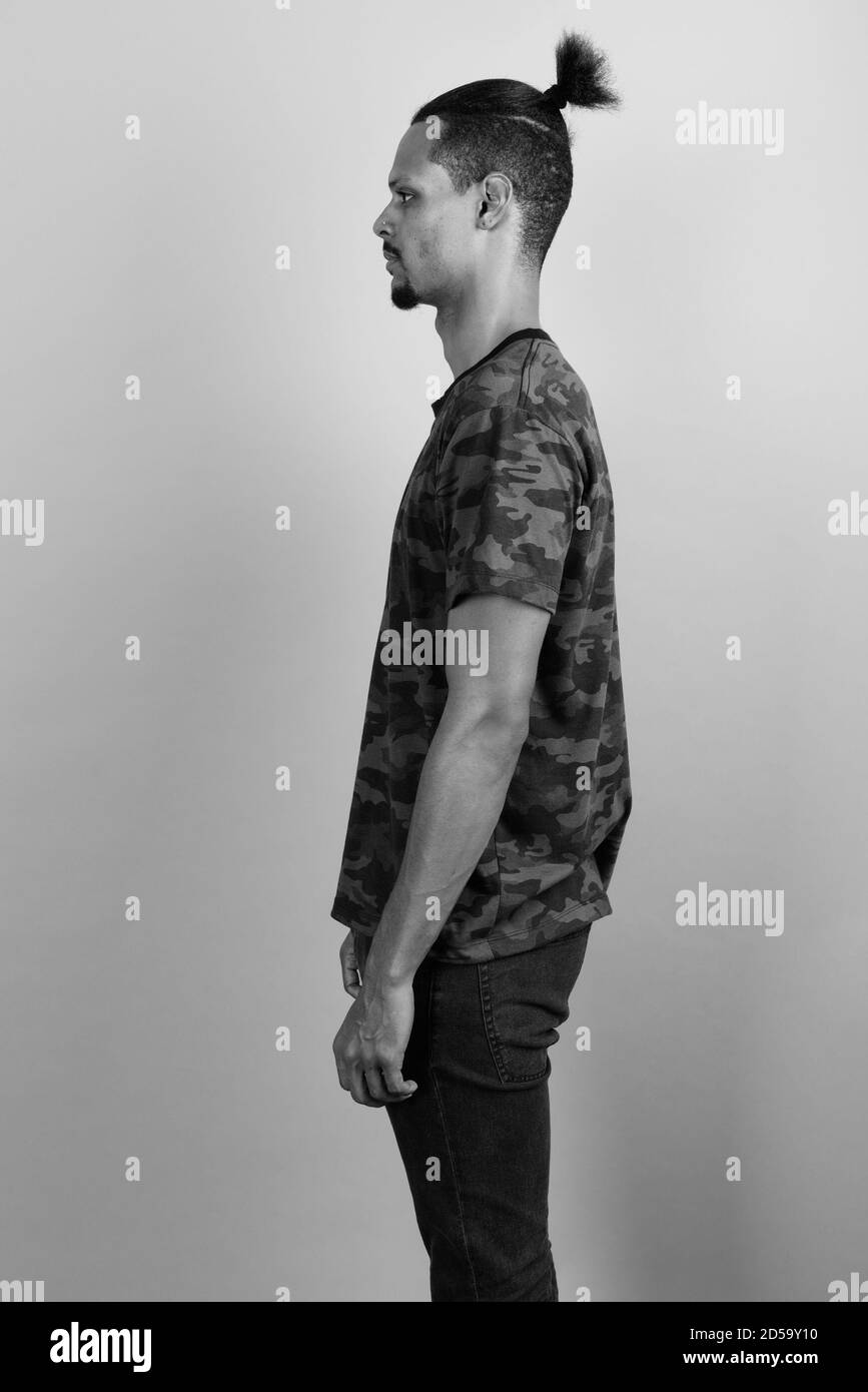 Beau jeune homme barbu africain contre l'arrière-plan gris Banque D'Images