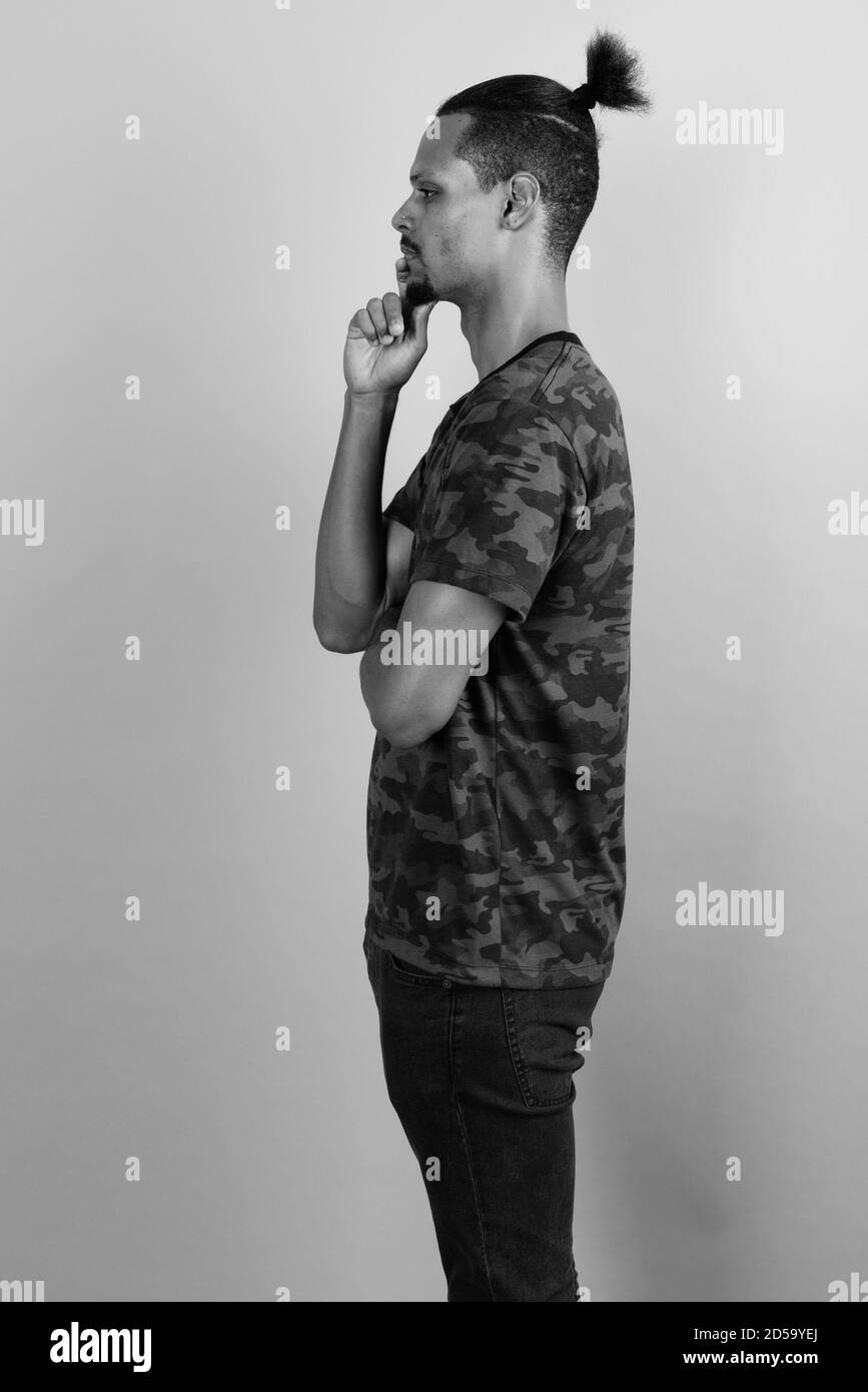 Beau jeune homme barbu africain contre l'arrière-plan gris Banque D'Images