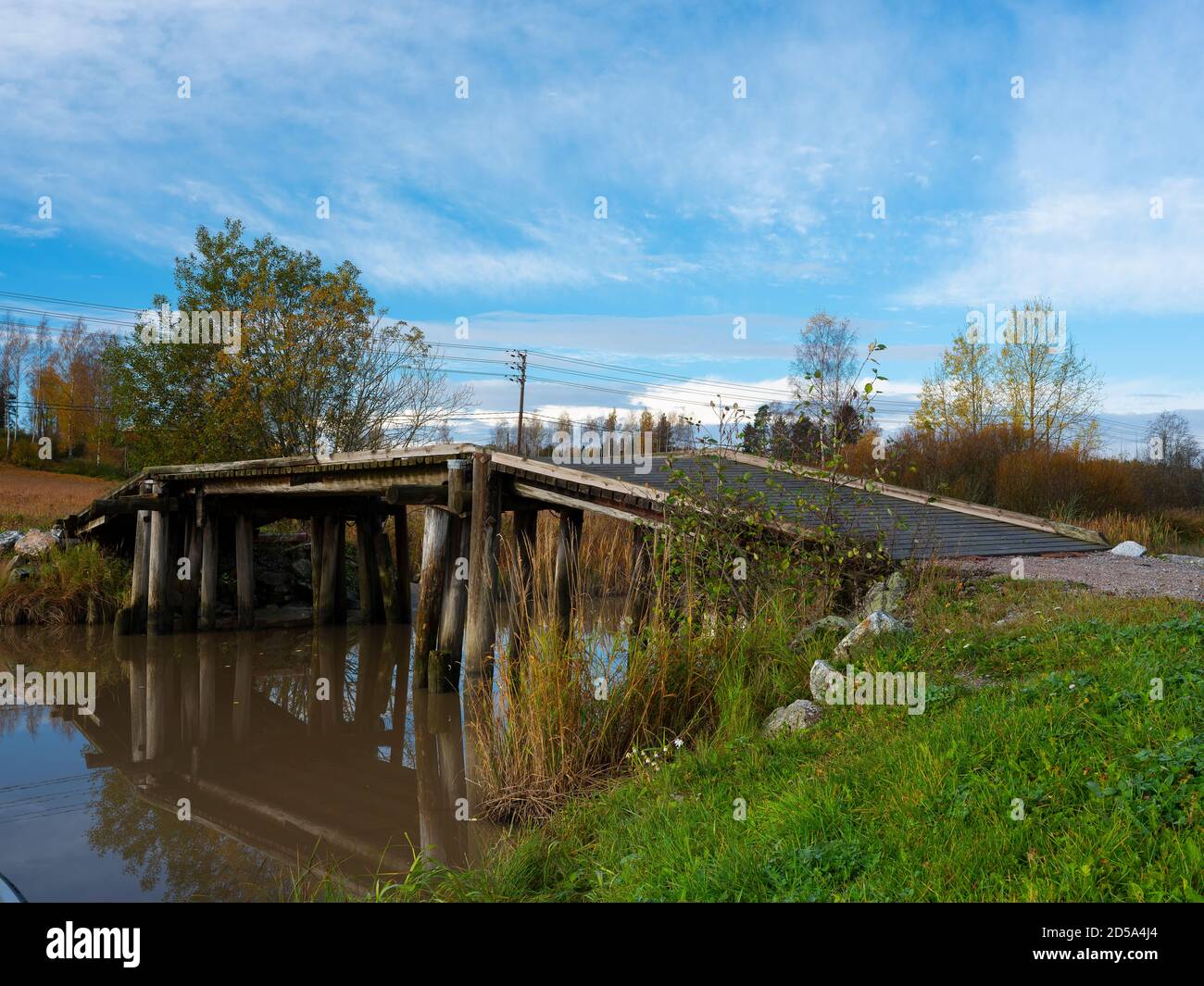 Sipoo/Finlande - 12 OCTOBRE 2020 : une belle scène rurale avec un vieux pont en bois qui jette des reflets sur la surface calme de la rivière. Banque D'Images