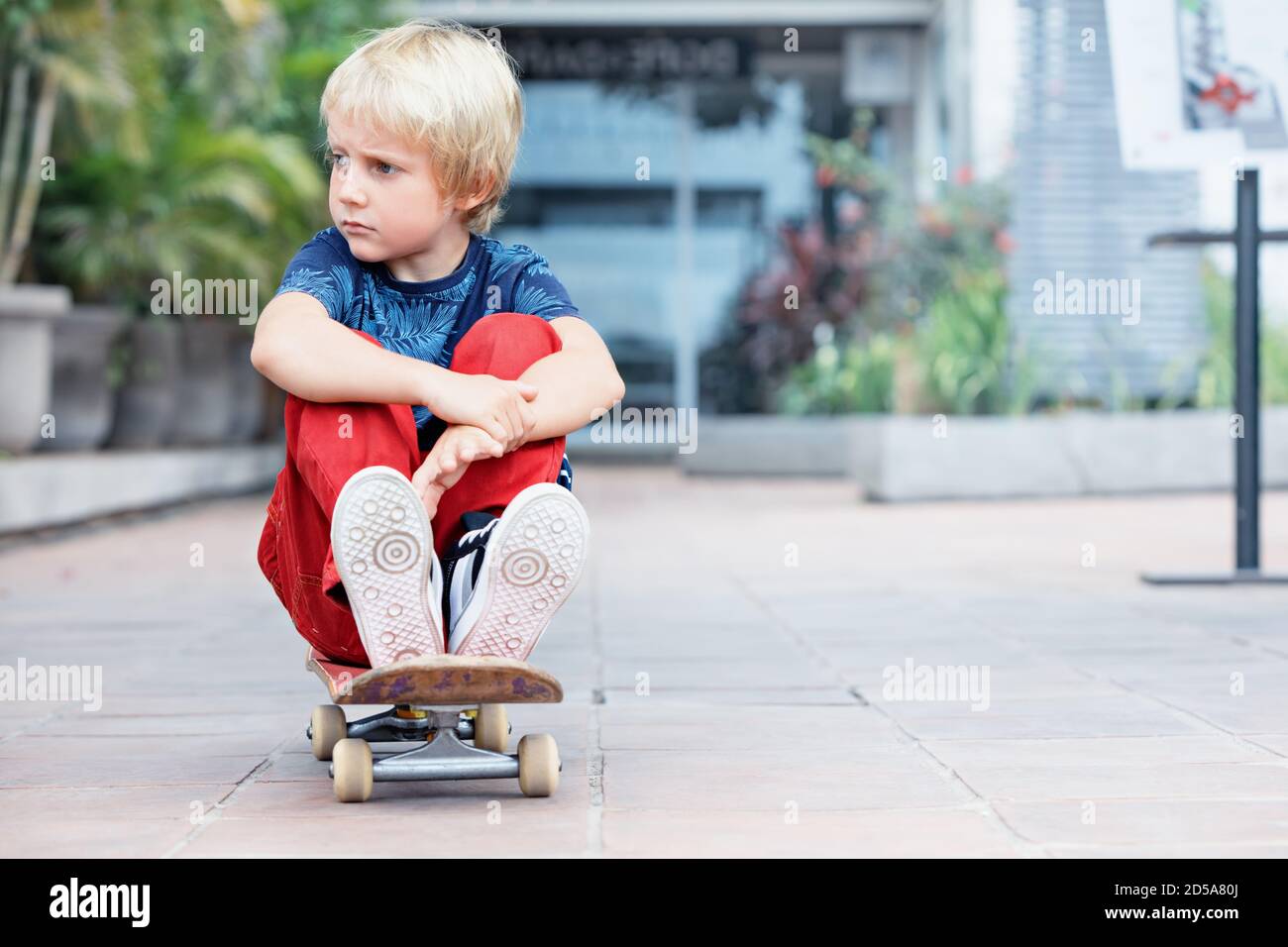 Peu de patineur avec skateboard s'amuser avant que les enfants de la classe de formation en skate park. Vie de famille active, l'été sur les activités récréatives de plein air Banque D'Images