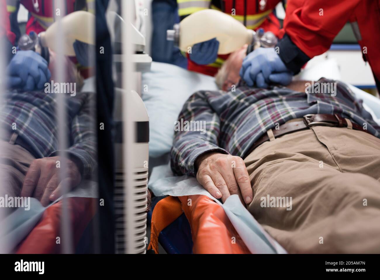Foyer sélectif de patients âgés allongé dans une voiture d'ambulance pendant ambulanciers paramédicaux effectuant la réanimation cardiopulmonaire Banque D'Images