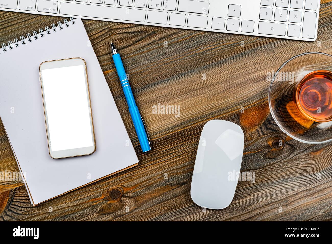 table de bureau avec clavier d'ordinateur, souris, tasse de thé et smartphone Banque D'Images