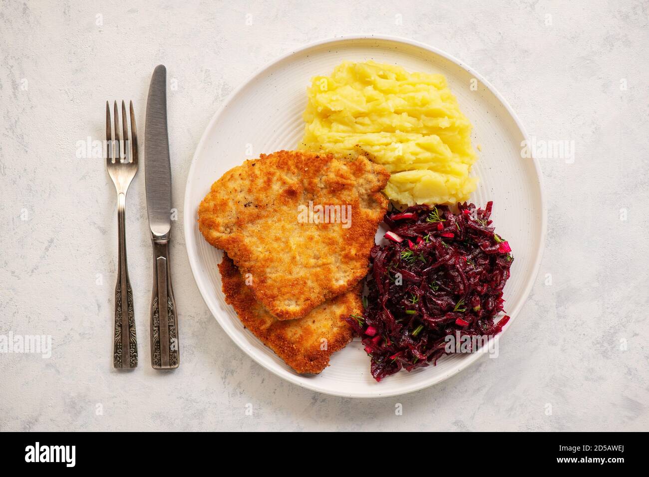 Hachez les côtelettes de porc, servies avec une purée de pommes de terre et une salade de betteraves. Banque D'Images