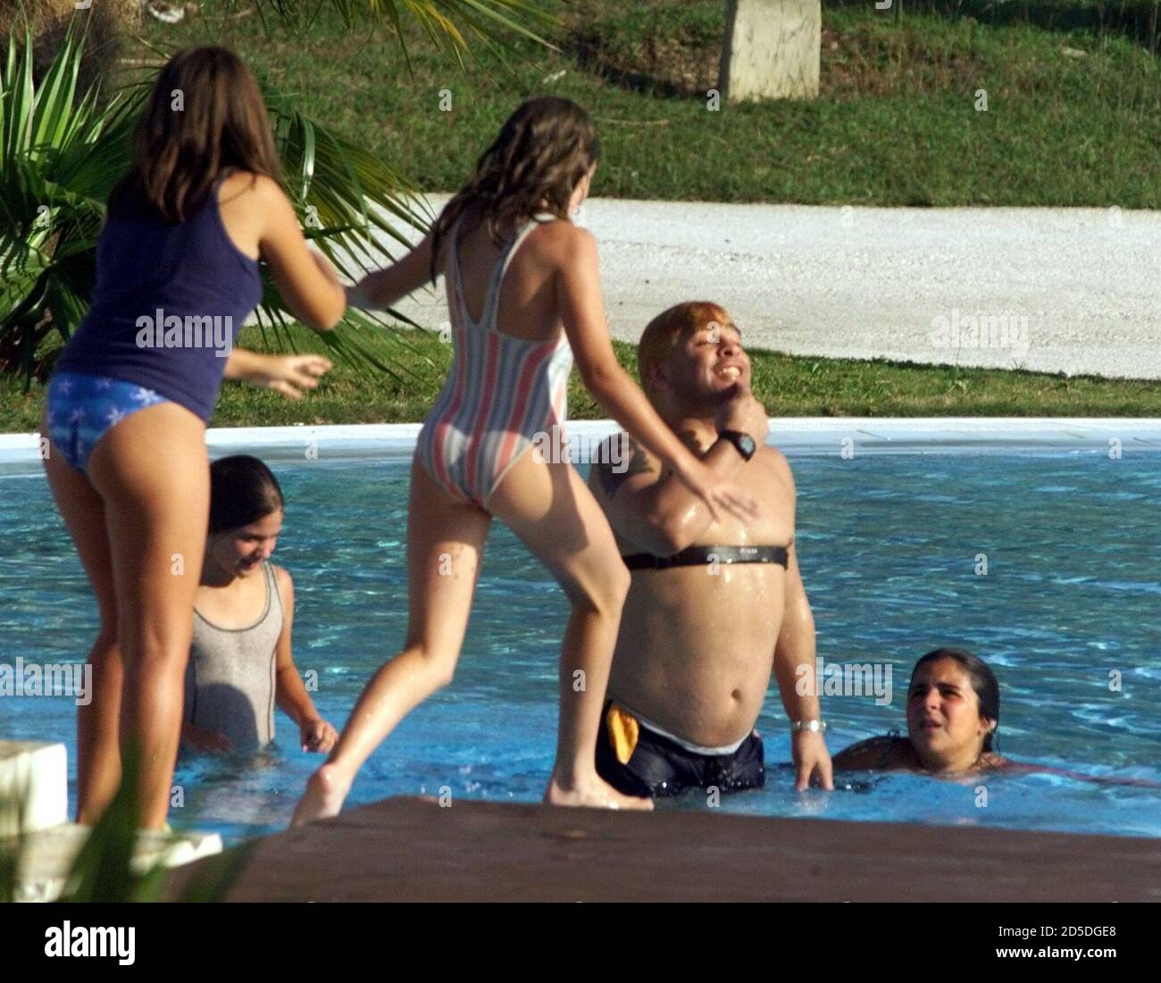 Argentine soccer star Diego Armando Maradona plays with his daughters Dalma  Nerea (R, on platform) and Yanina Dinora (L, in water) and two other  unidentified relatives, in a pool at the exclusive