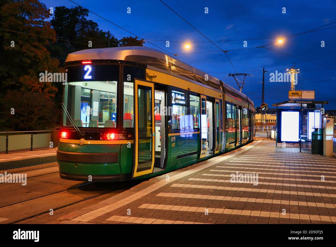 Le tramway n° 2 de HSL s'arrête le matin avant l'aube, avec des feux de rue éclairant la vue sur la ville. Helsinki, Finlande. 29 septembre 2020. Banque D'Images