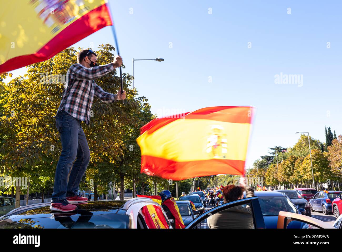 Madrid, Espagne, 12 octobre 2020. Des gens portant un masque agitant le drapeau alors qu'ils assistent à une manifestation contre la gestion de la crise COVID-19 par le gouvernement espagnol. Banque D'Images