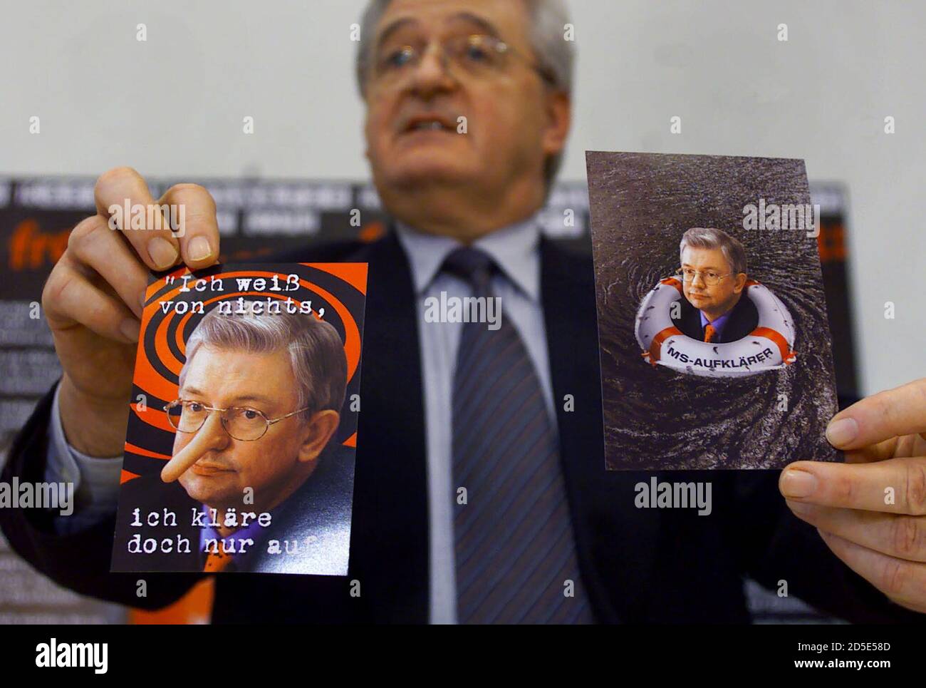 Armin Clauss, parliamentary floor leader of the opposition Social  Democratic Party (SPD) in the state parliament of the German state of  Hesse, displays postcards which show Hesse's Prime Minister Roland Koch, of