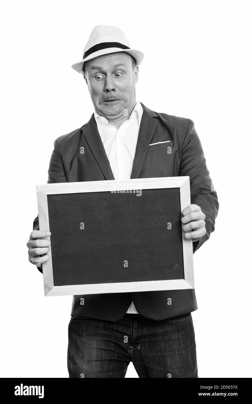 Mature businessman holding blank blackboard en regardant choqué et surpris Banque D'Images
