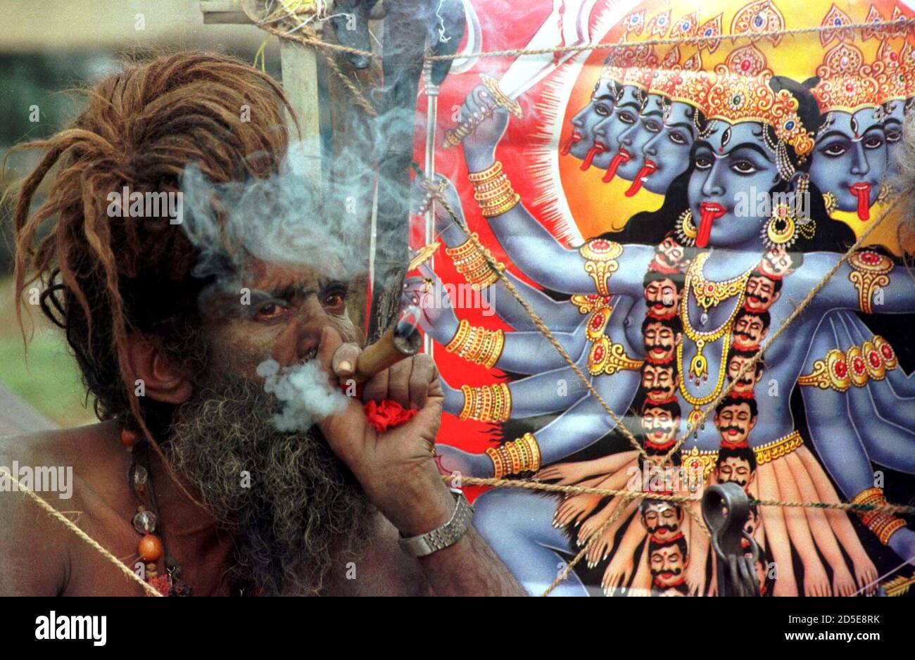 A Hindu Naga monk, Mahanta Shivagiri smokes cannabis in a pipe in front of  an image of Kali, the Hindu goddess of power in the eastern Indian city of  Calcutta January 6.