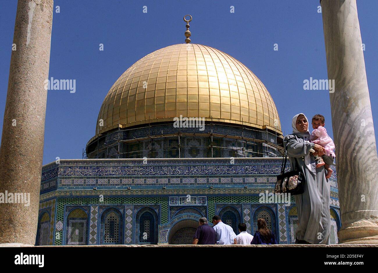 A Palestinian woman carries her child as she leaves the Dome of the Rock  after praying in the Temple Mount complex which includes Al-Aqsa Mosque,  Islam's third most holy site in Jerusalem's