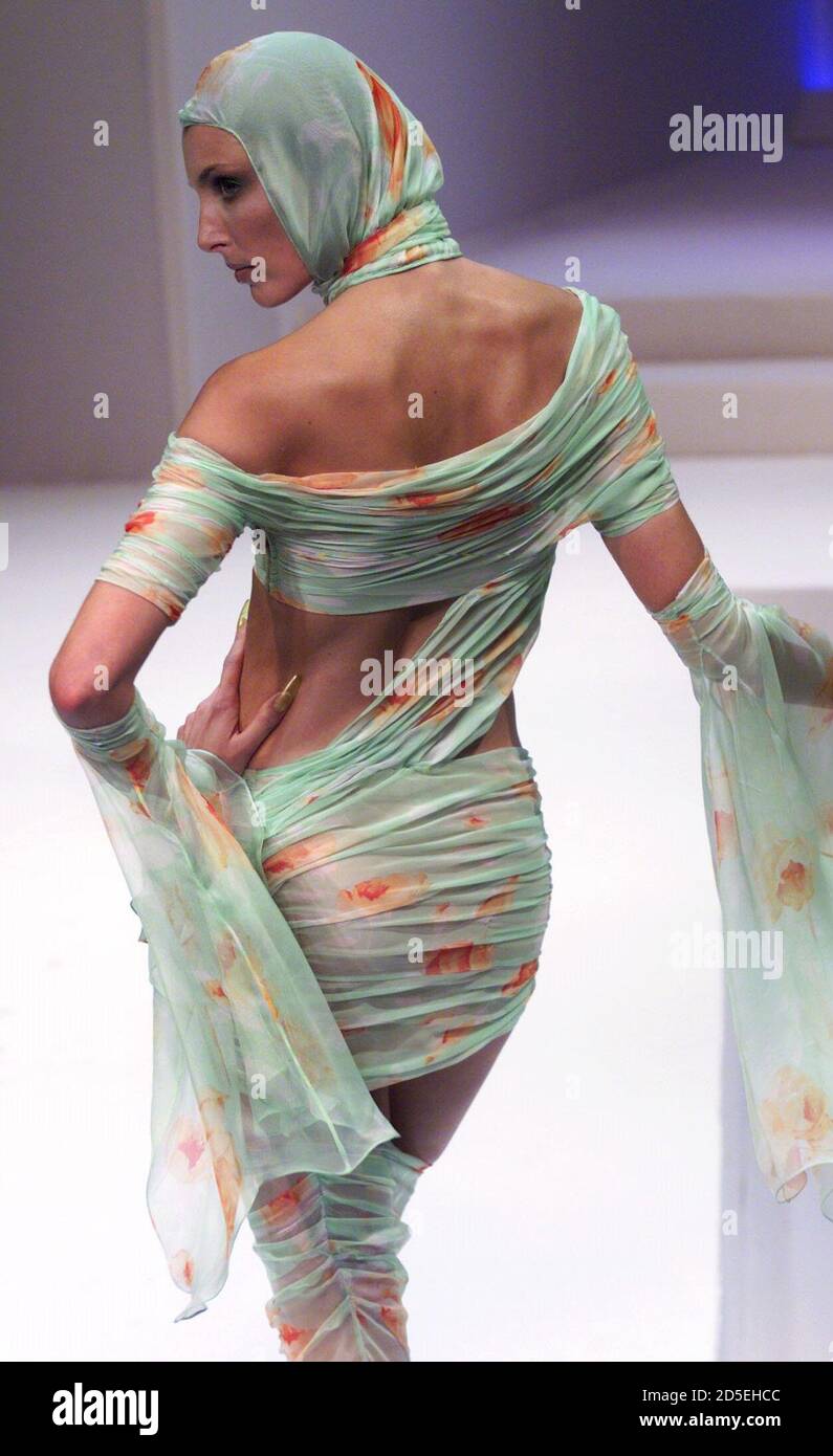 Un modèle pour le designer de mode français Thierry Mugler présente cette  robe verte de style sari avec un motif floral orange et un foulard assorti  dans le cadre de sa collection