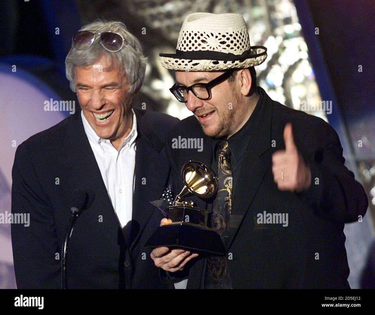 Elvis Costello (L) gives a thumbs up as he accepts his Grammy Award with collaborater Burt Bachrach after winning for the Best Pop Collaboration with Vocalsduring the 41st Grammy Awards February 24. Costello and Bacharach won for their record "I Still Have That Other Gift". ??» Banque D'Images