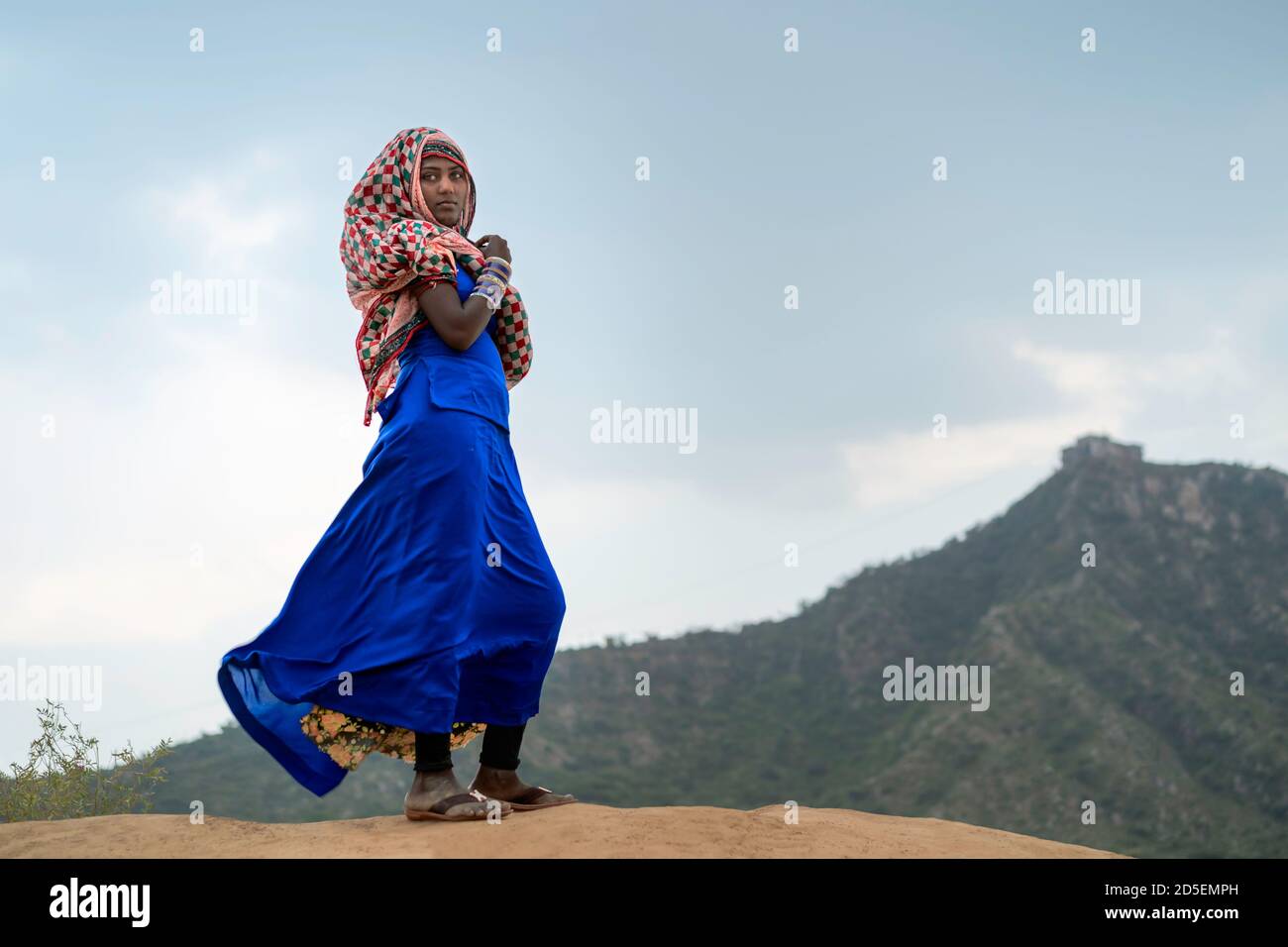 Jeune gitane en vêtements traditionnels couvrant une partie de son visage dans le désert de Thar à l'aube à Pushkar, Rajasthan, Inde. Banque D'Images