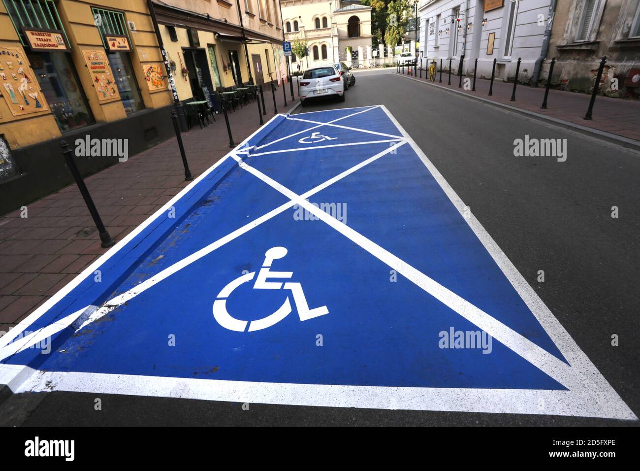 Cracovie. Cracovie. Pologne. Place de stationnement bleue vide pour les personnes handicapées, symbole fauteuil roulant. Vue sur la rue. Banque D'Images