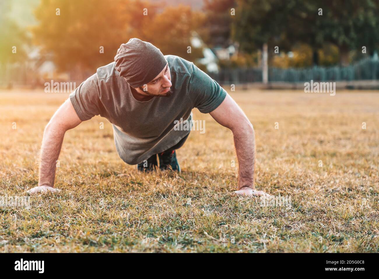 Sports et yoga. Un homme dans les push-up de sport pendant l'entraînement. Parc et arbres en arrière-plan. Copier l'espace. Banque D'Images