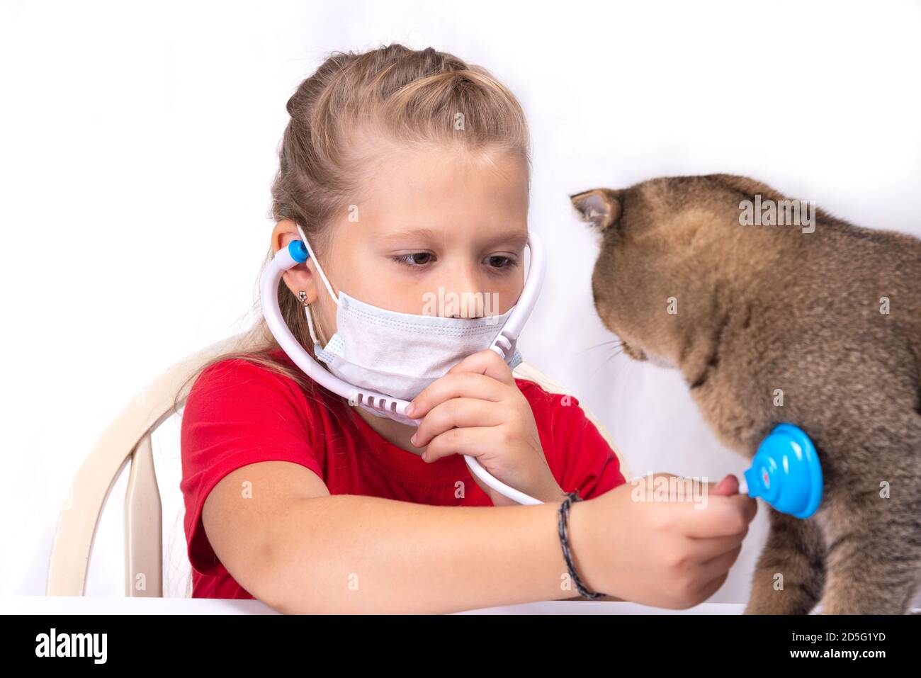 Petite fille jouant au vétérinaire - en consultant son petit chaton Banque D'Images