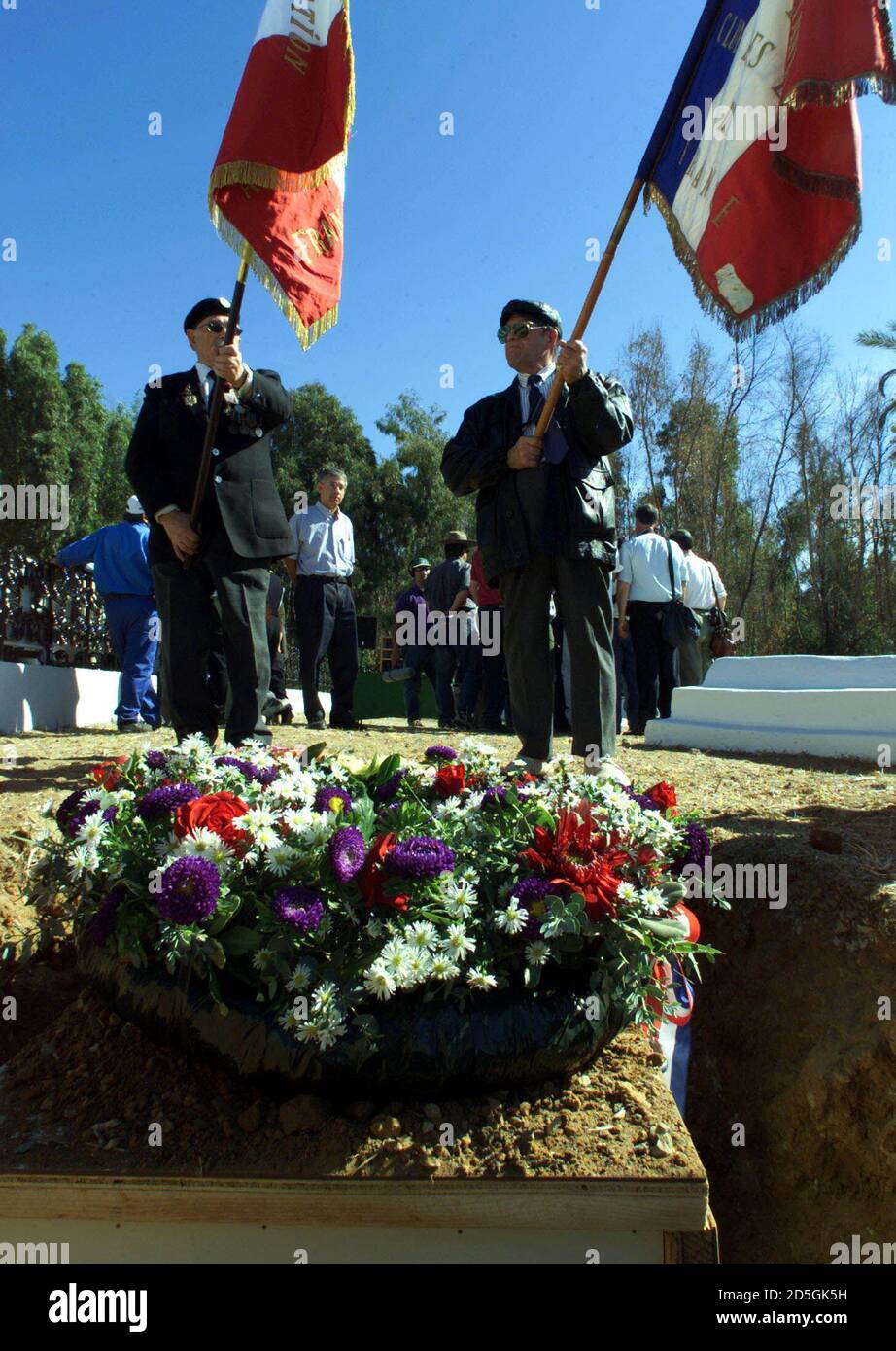Unidentified French flag bearers stand over the shallow grave containing a  coffin covered in two wreaths with the remains of four French soldiers who  served under Napoleon Bonaparte and died in the