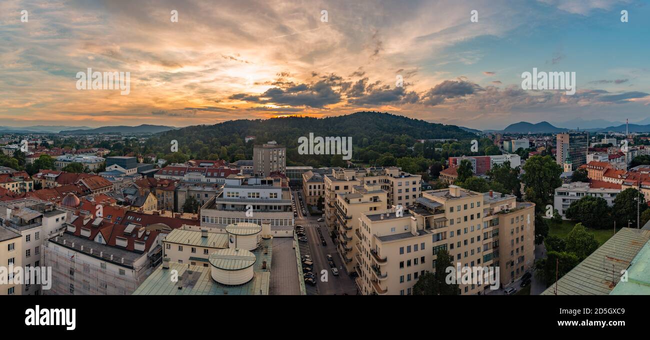 Une vue panoramique du soleil qui se couche sur la zone verte de Rožnik et la ville de Ljubljana. Banque D'Images