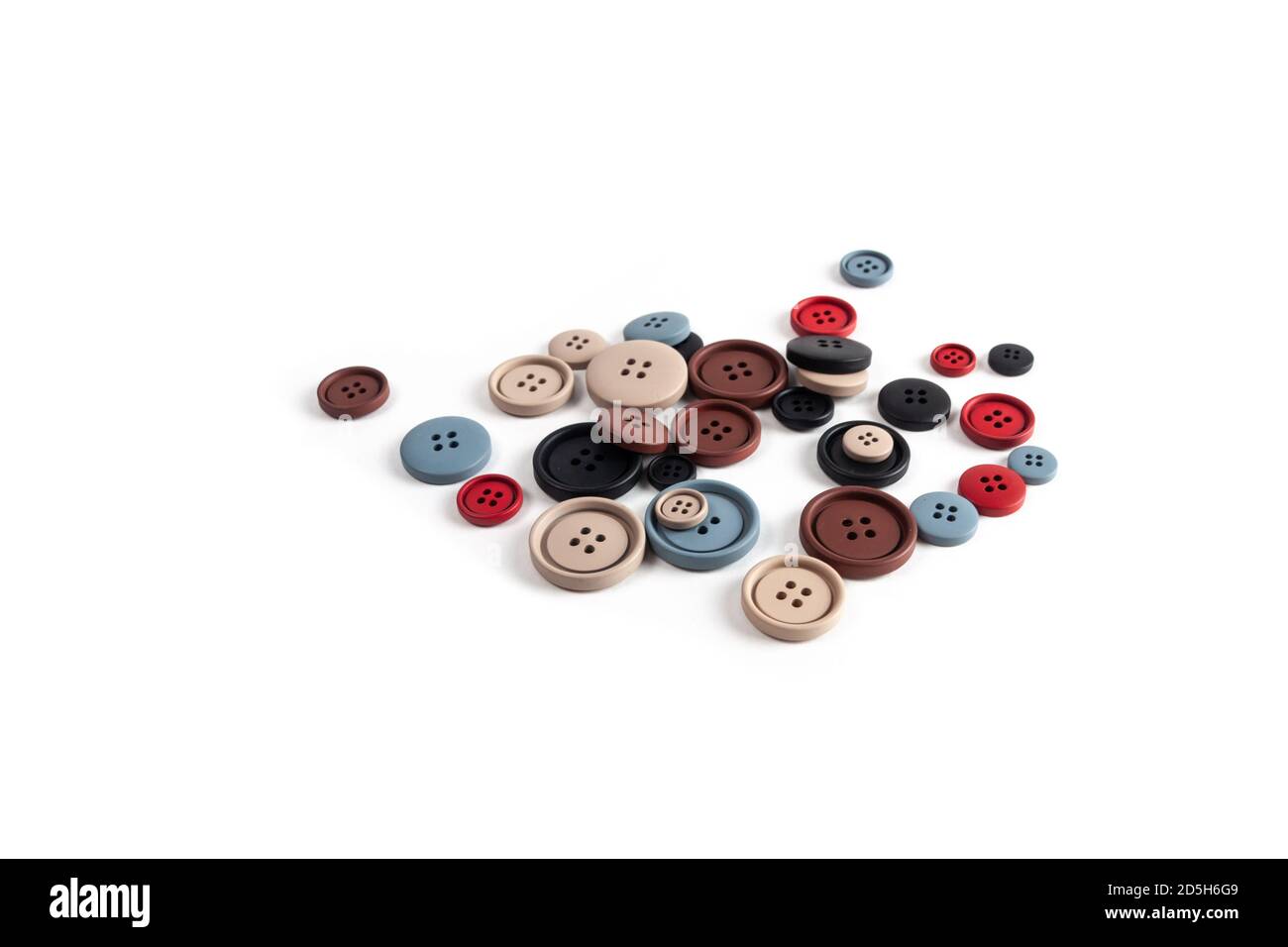 Pile de couleur marron, beige, gris, rouge, noir plastique matte boutons sur blanc, beau needlwork, minimalisme. À utiliser pour la couture. Espace pour le texte. Banque D'Images