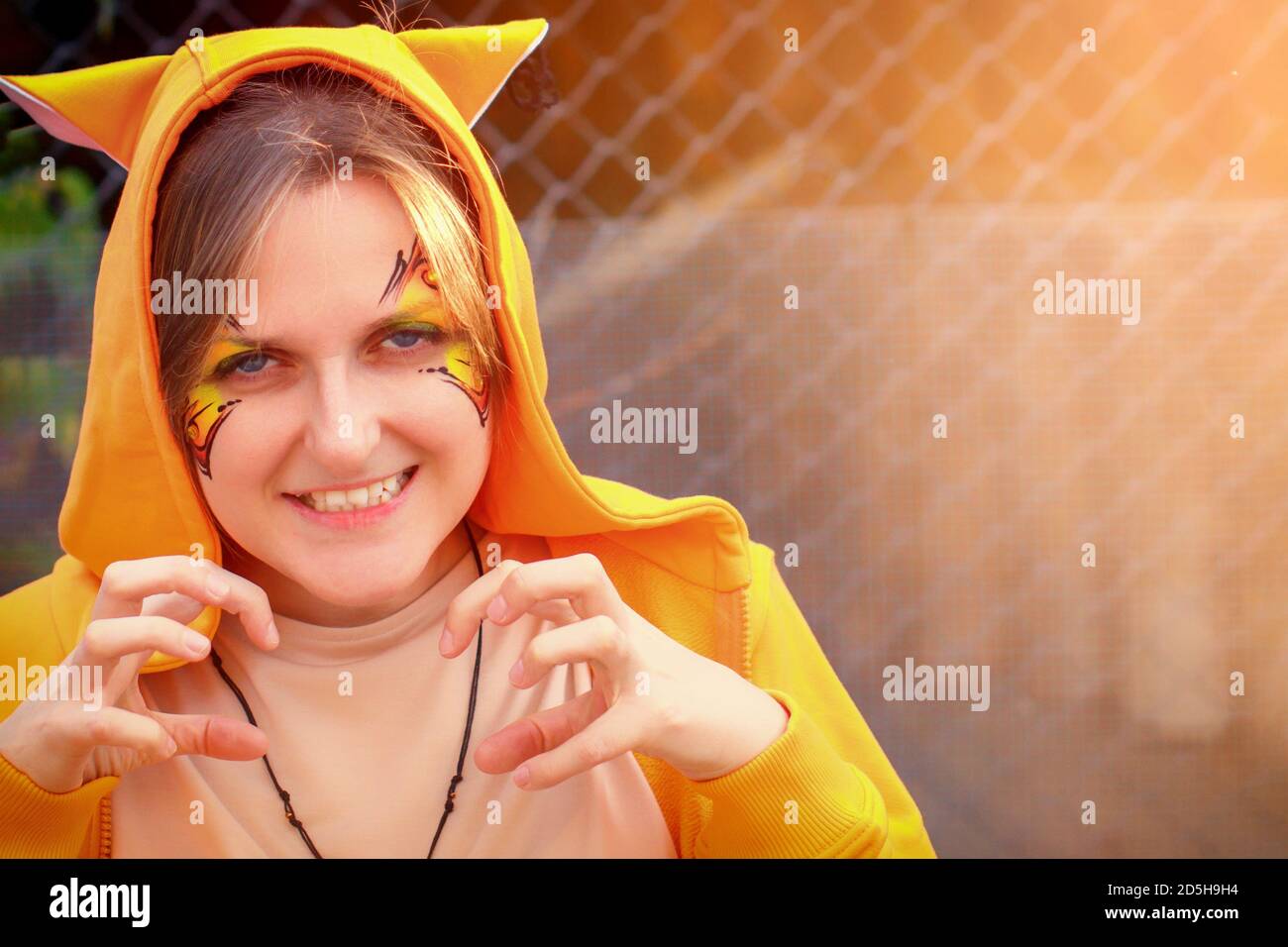 Fille Montre Le Chat Une Femme Avec Un Motif Sur Son Visage Dans Des Vetements Orange Un Costume Ecureuils Fox Ou Bobcats Dessin De Peintures De Papillons Jour D Ete Ensoleille Photo Stock