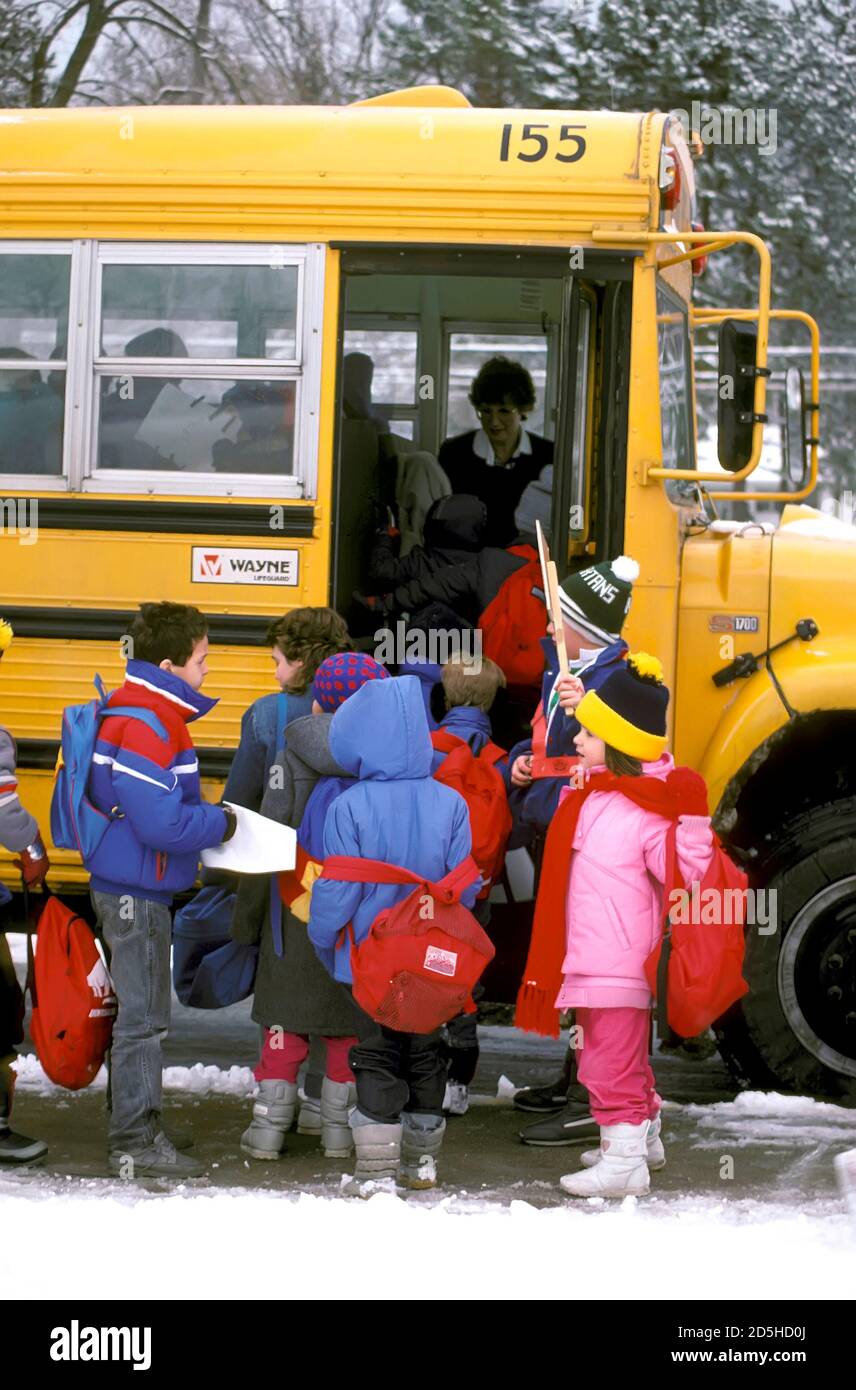 Patrouille élémentaire boy supervise l'embarquement d'un autobus scolaire par des étudiants Banque D'Images